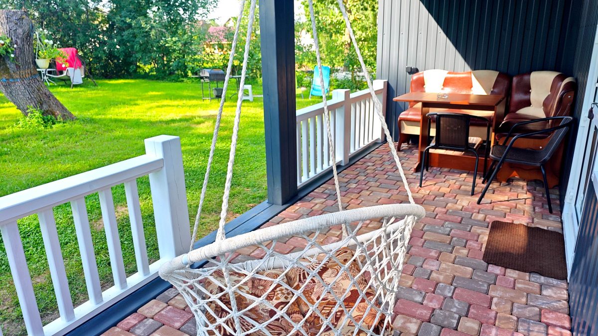 На террасе качели, стол и стулья