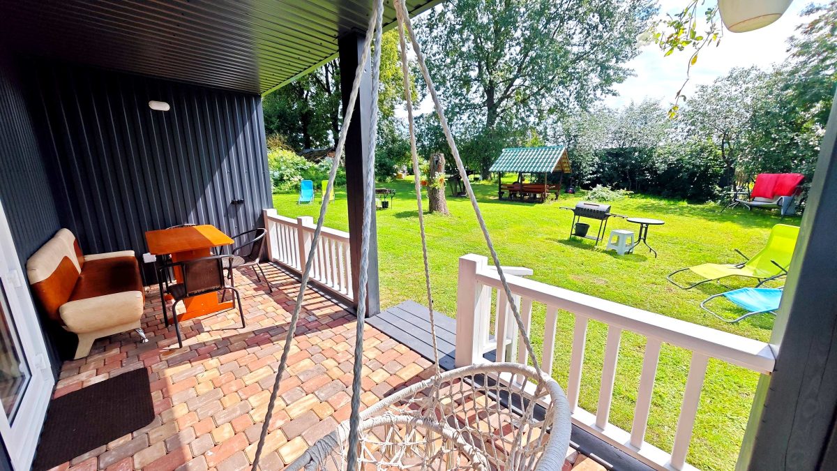 На террасе качели, стол и стулья