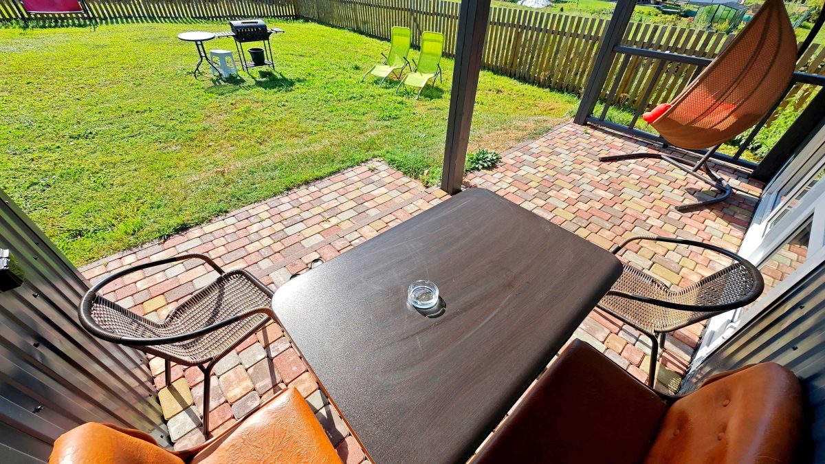 Коричневый домик-студия. Перед террасой собственная лужайка и мангал со столиком