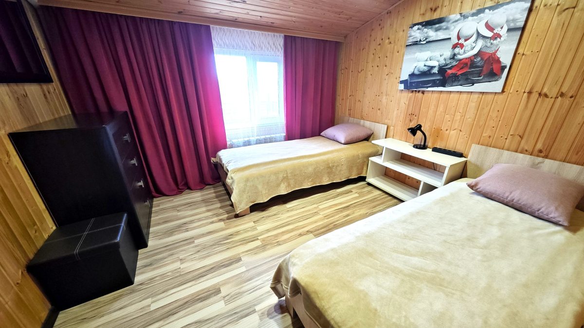 Бежевые апартаменты. Две односпальных кровати и комод  во второй спальне. Вид на озеро.