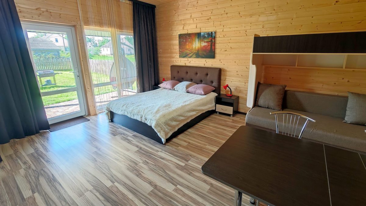 Коричневый домик-студия. Большая двухспальная кровать шириной 160 см.