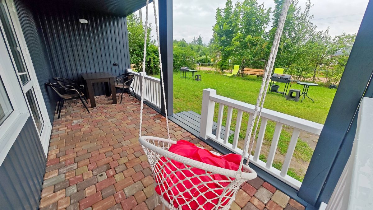 Перед террасой лужайка и мангал со столиком