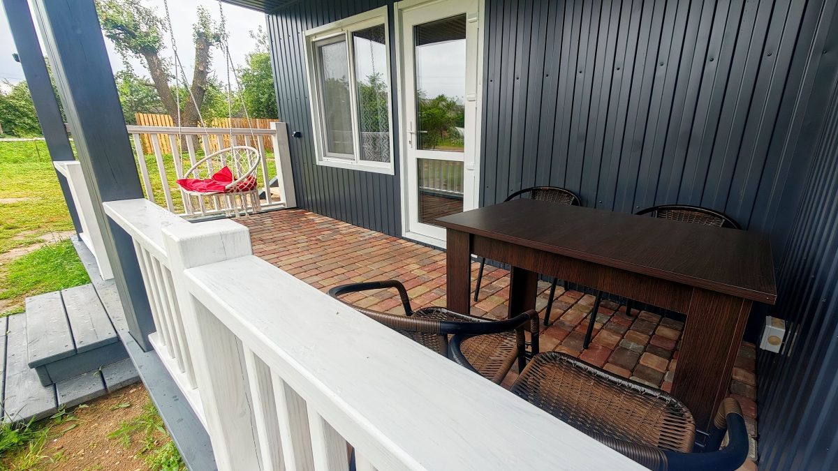 На террасе качели, стол и стулья